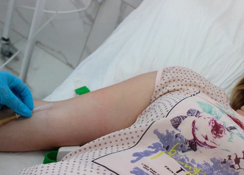 Пациент лежит на кушетке Врач собирается ставить капельницу